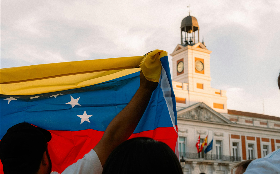 Venezuelan flag in front of a historic building at sunset